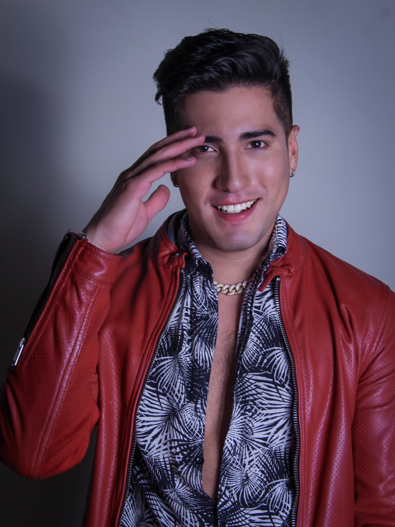 FRANKOWW sonriendo con la mano junto a la cabeza