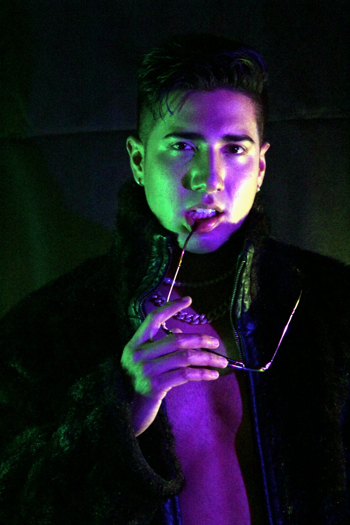 FRANKOWW con abrigo negro bajo luces verdes y violetas